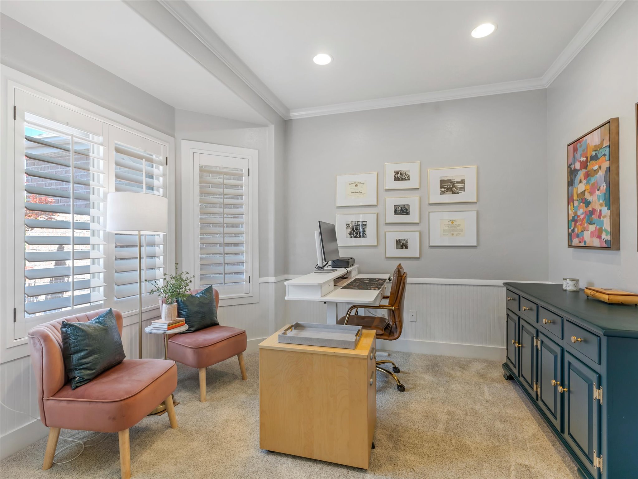 Dedicated office space featuring bay windows with plantation shutters, recessed lighting, crown molding, wainscoting, and carpet flooring