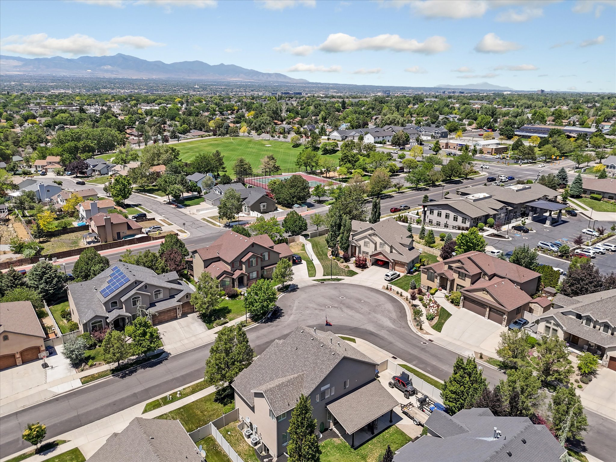 Residential neighborhood featuring mature trees and mountain scenery