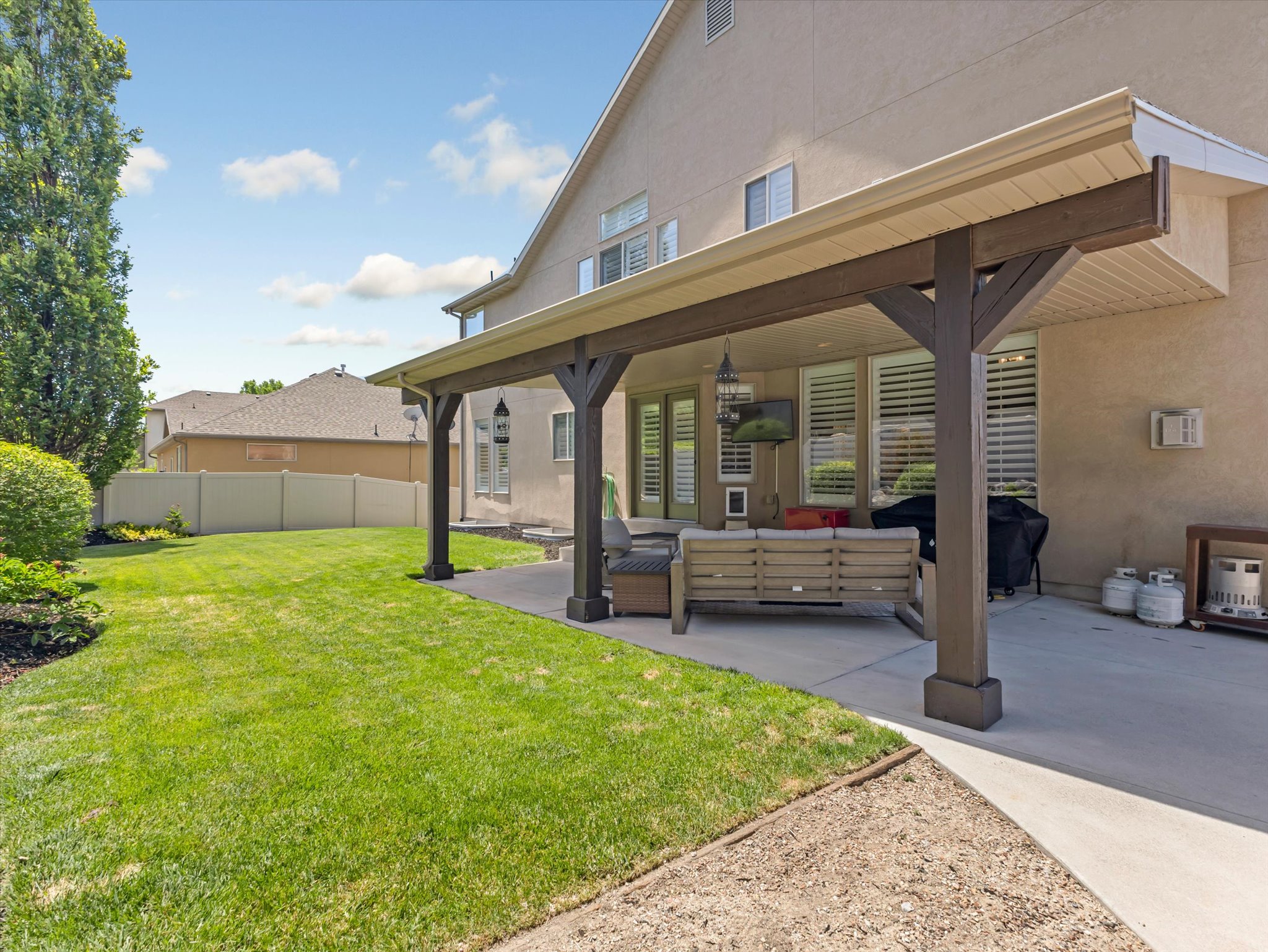 Expansive covered patio with exposed beam construction, providing sheltered outdoor living