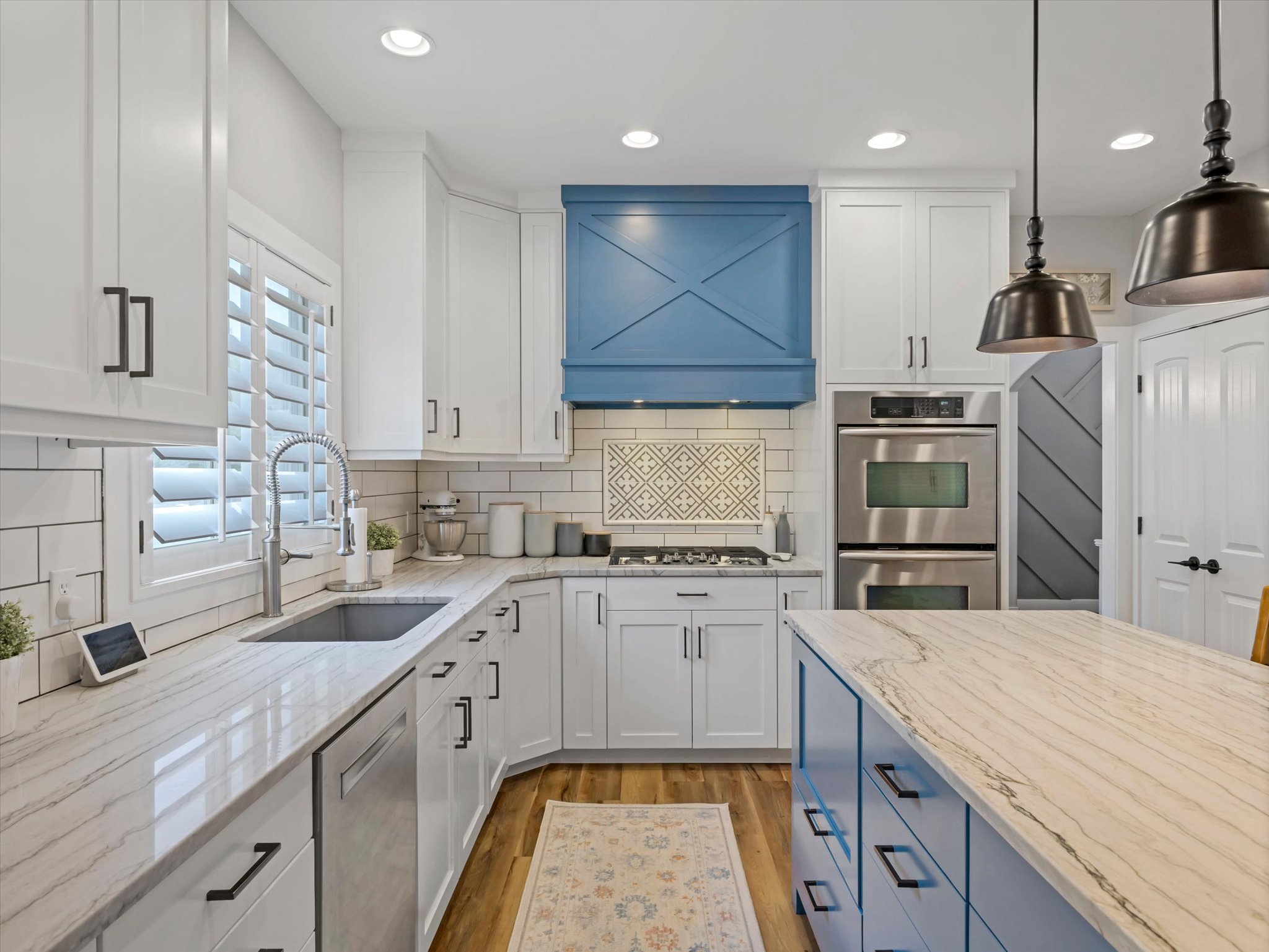 Contemporary kitchen featuring white cabinetry, light countertops, and wood-finish flooring