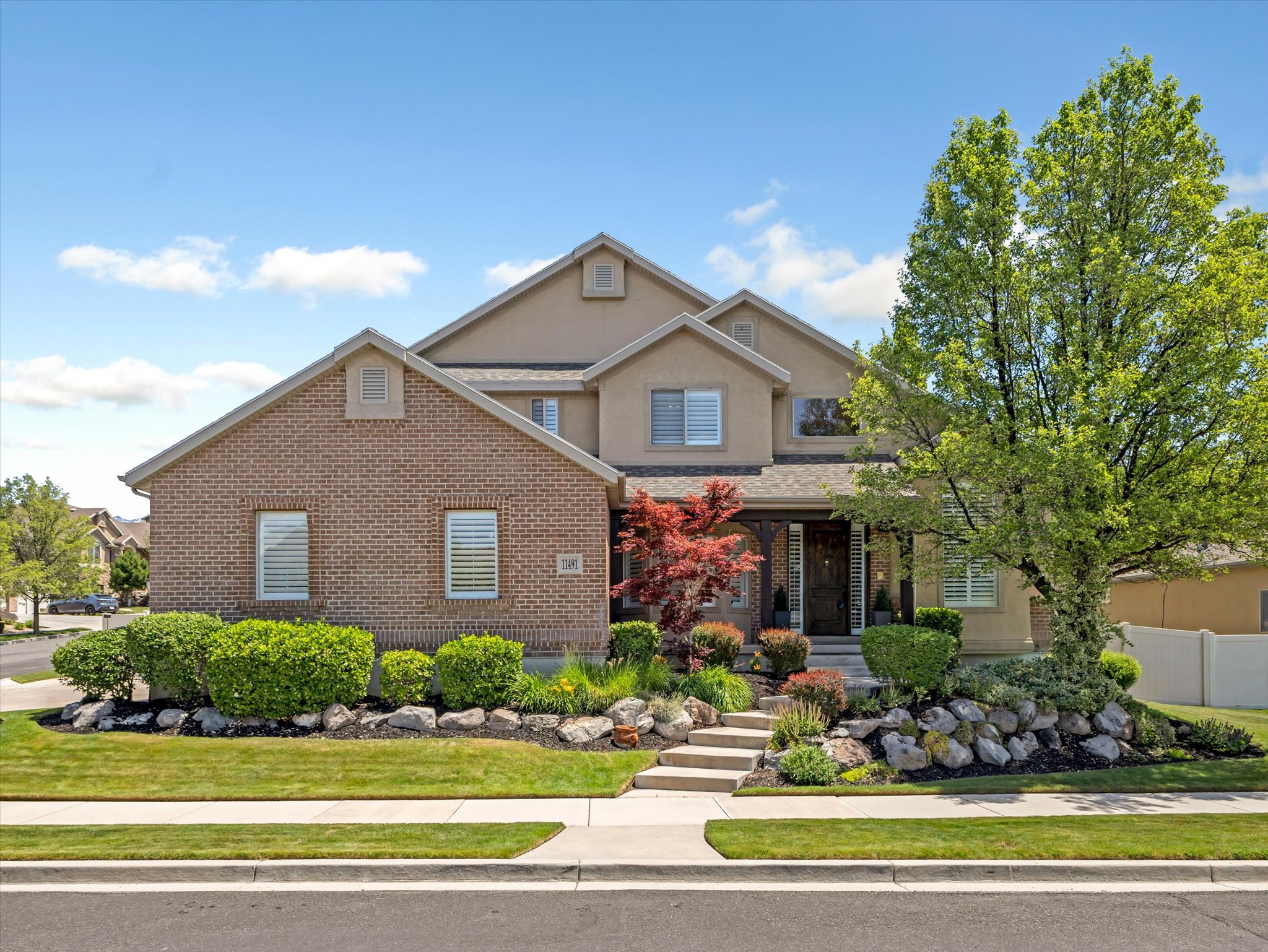 Brick and stucco exterior featuring multiple gables and dormer windows
