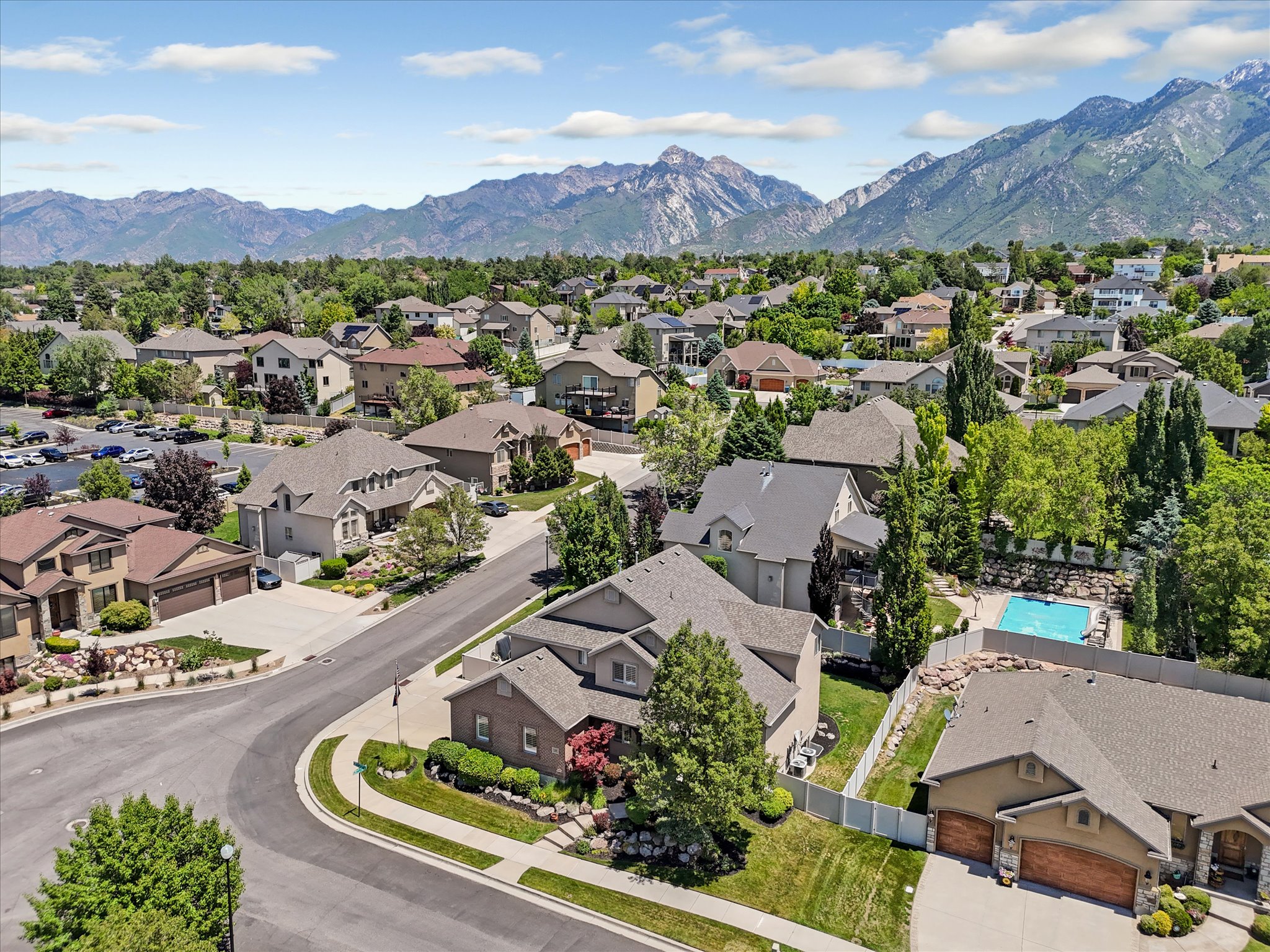 Residential community featuring a variety of architectural styles, mature trees, and mountainous terrain in the background
