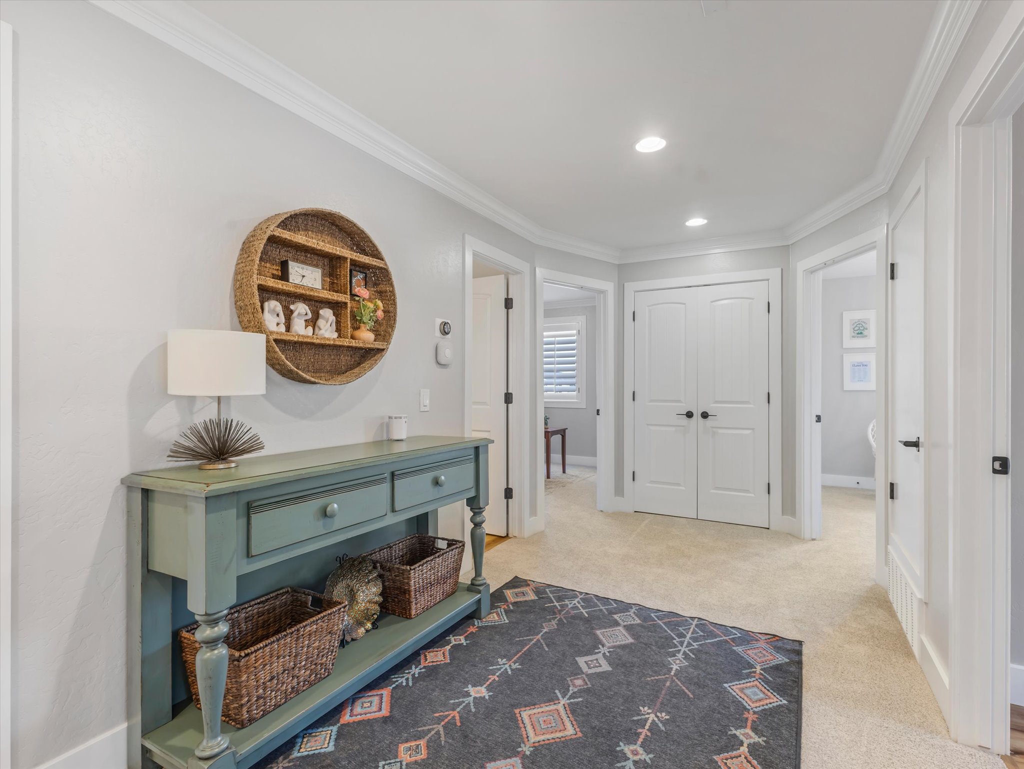 Well-lit hallway with recessed lighting, crown molding, double doors, and light-colored carpeting