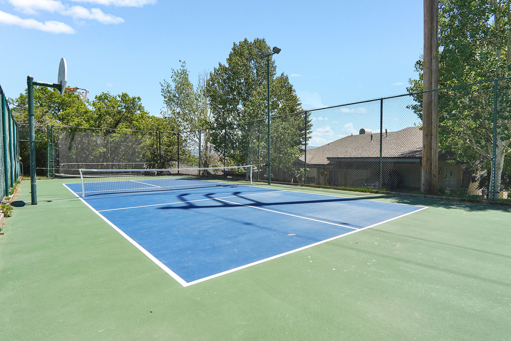 Private outdoor Pickleball court featuring a blue and green playing surface