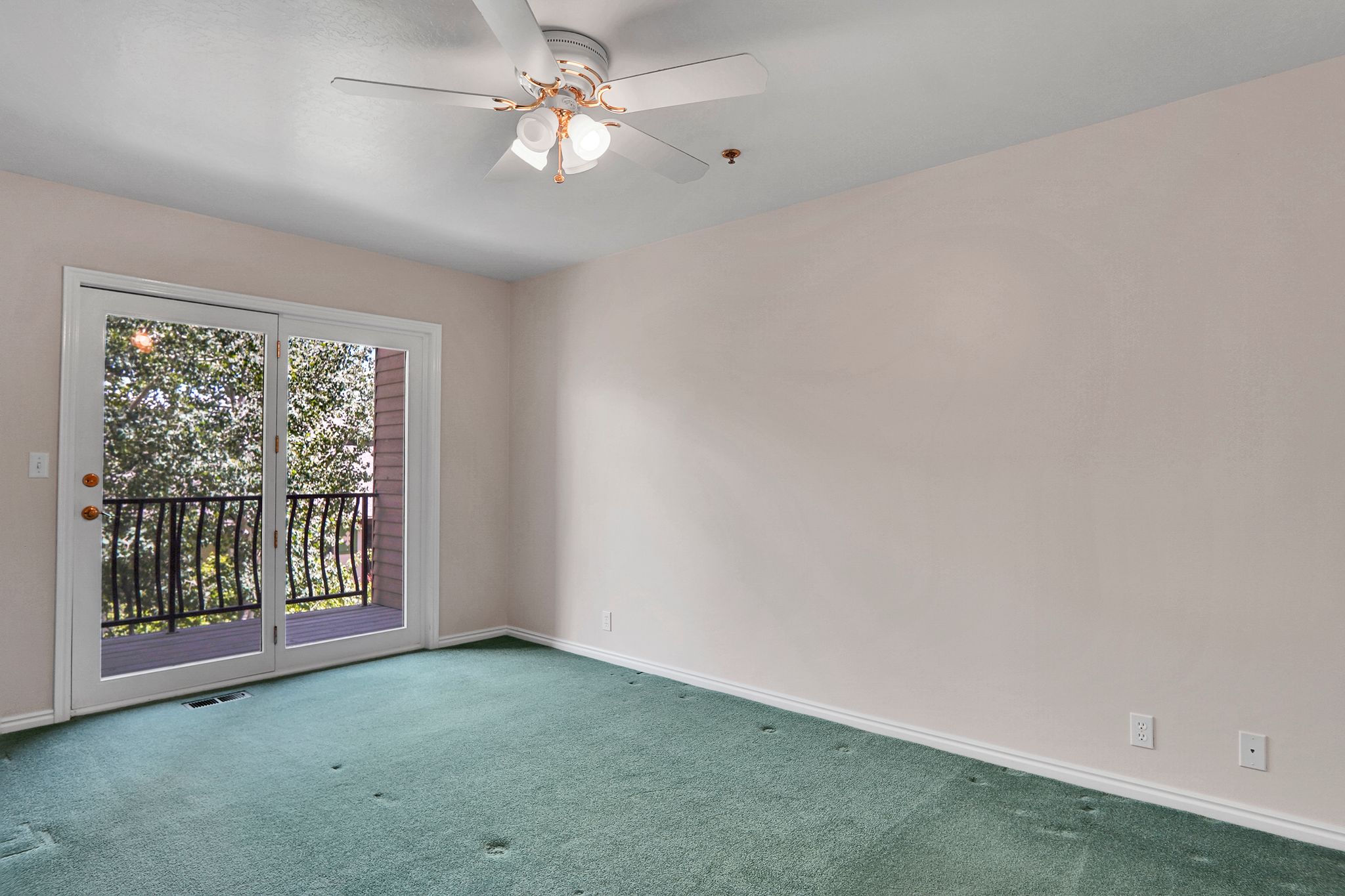 Room with wall-to-wall carpeting and a ceiling fan