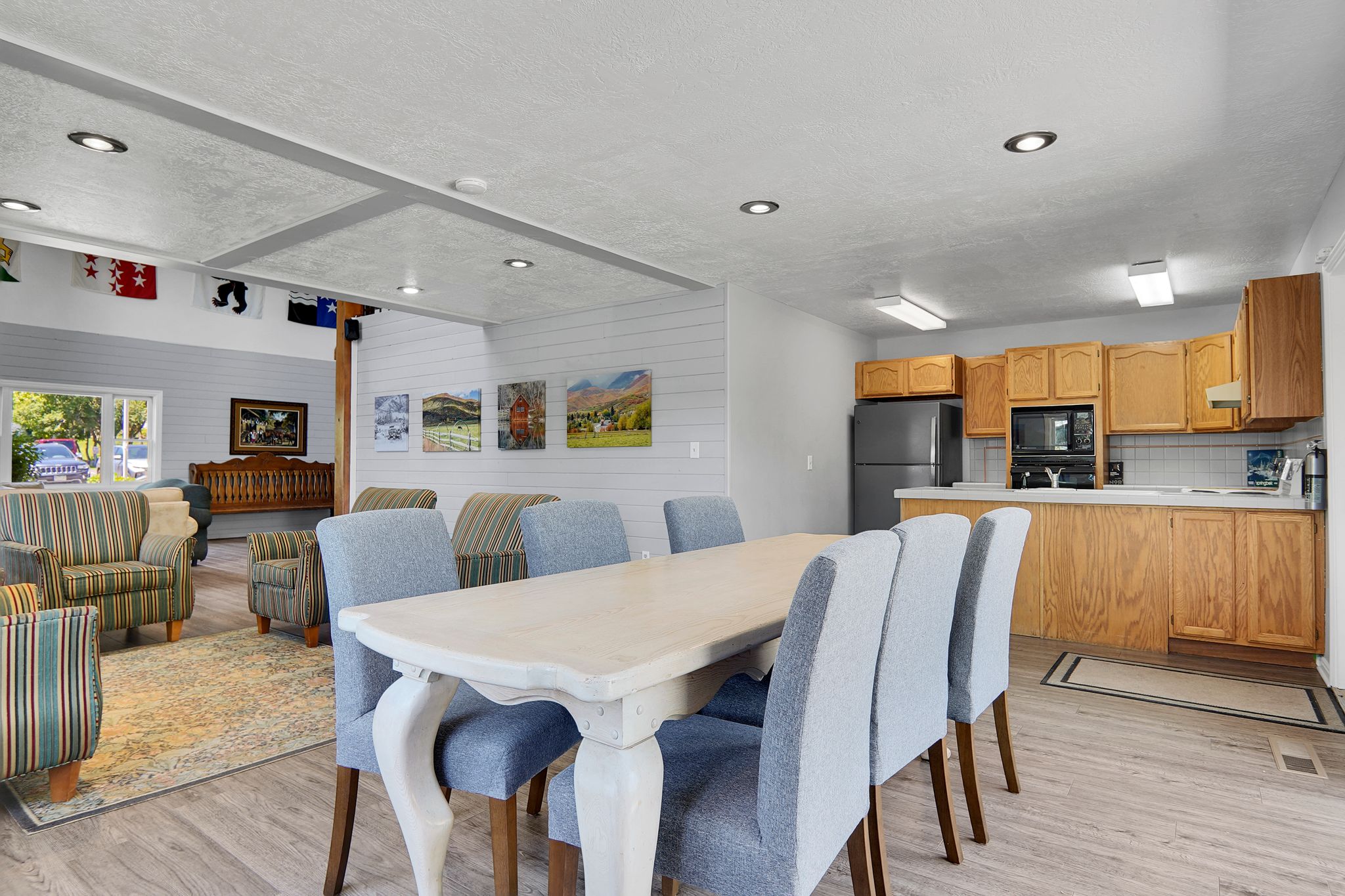 Open-concept room featuring wood-finish flooring, recessed lighting, and a dining area with a light-toned table
