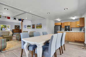 Open-concept room featuring wood-finish flooring, recessed lighting, and a dining area with a light-toned table