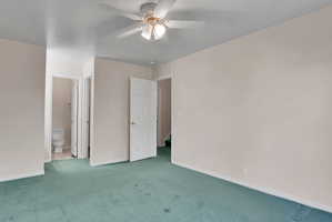 Spacious room featuring light-toned walls and green carpeting