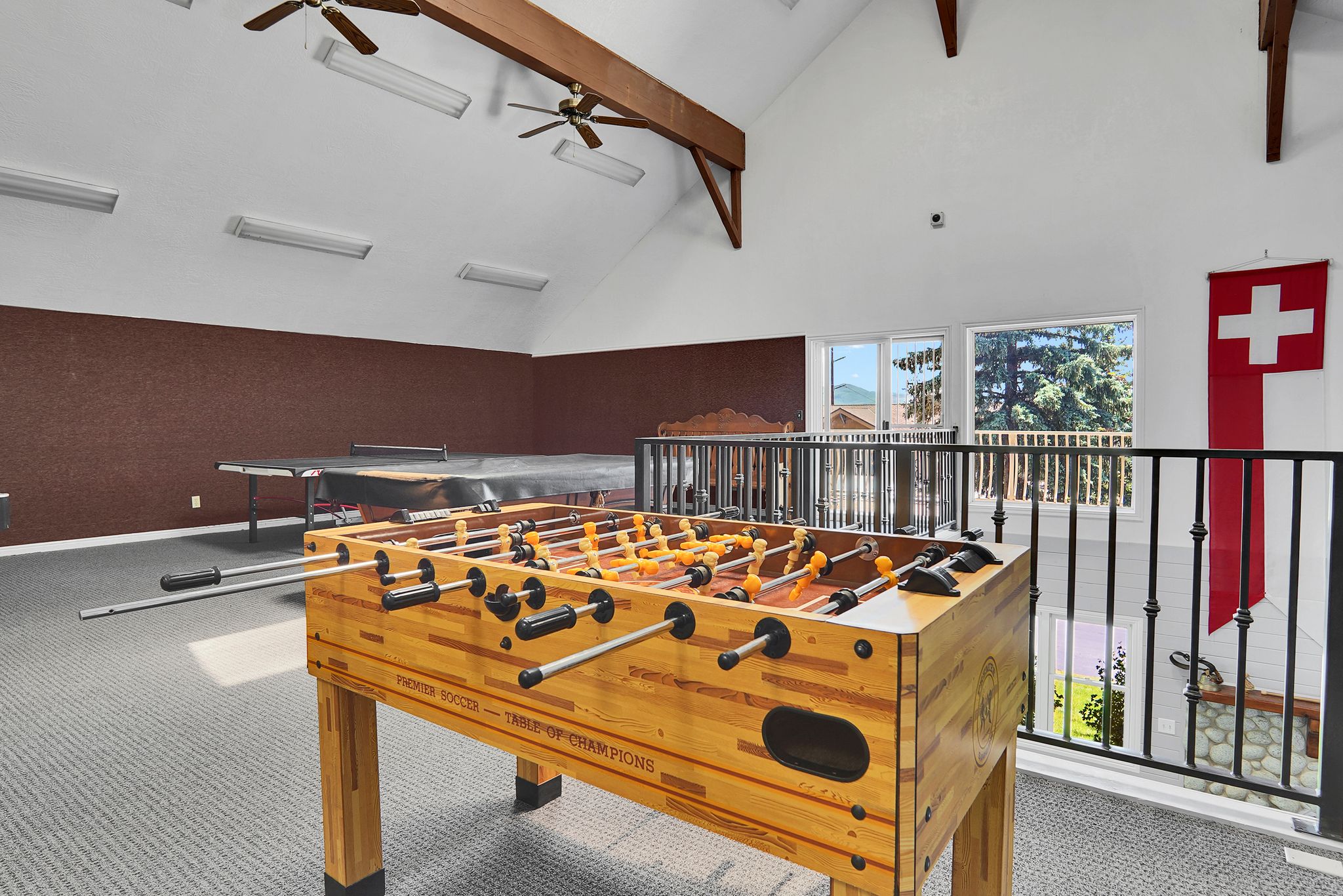 Spacious loft area featuring vaulted ceilings with exposed wood beams