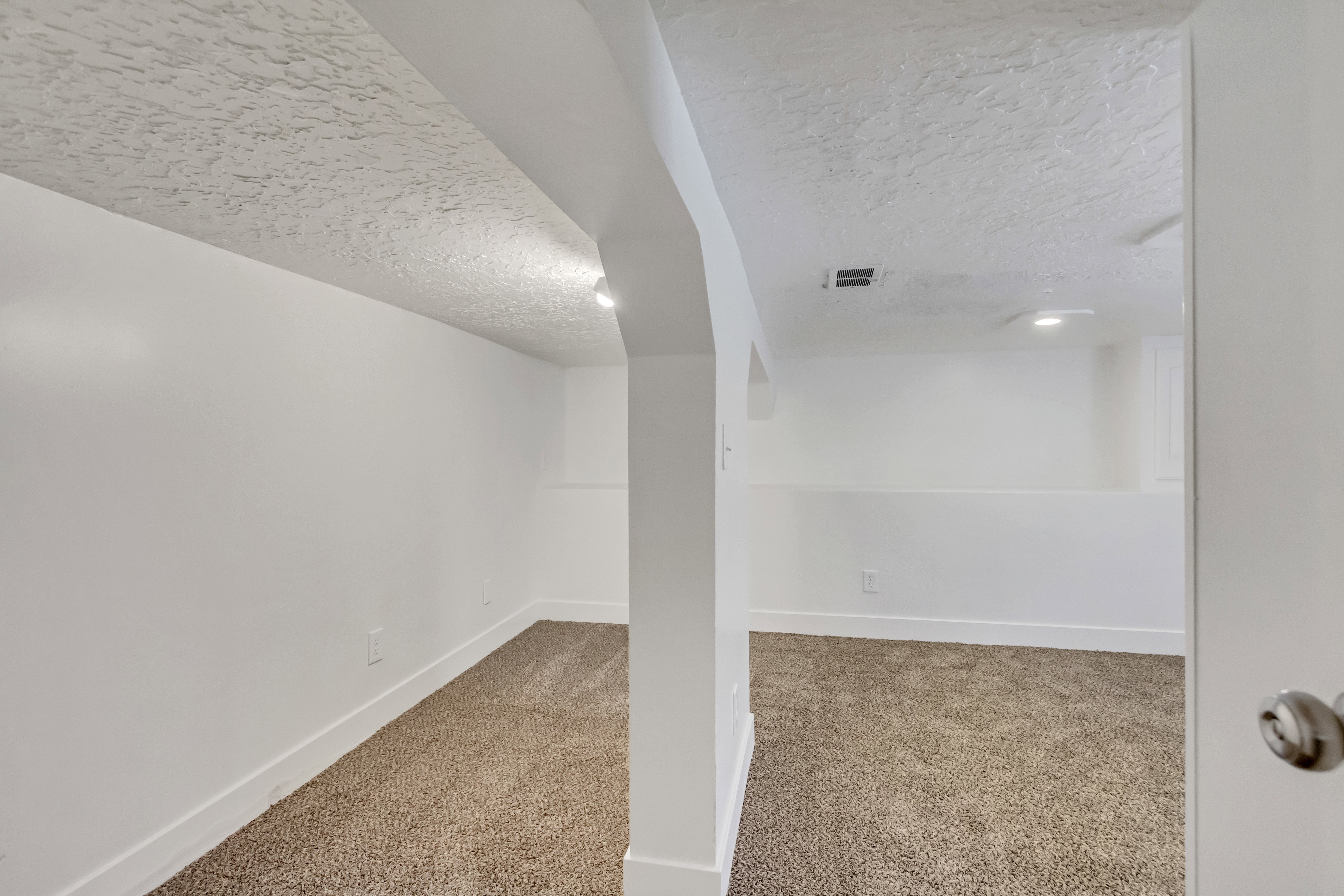 Spacious carpeted room featuring recessed lighting and white baseboards
