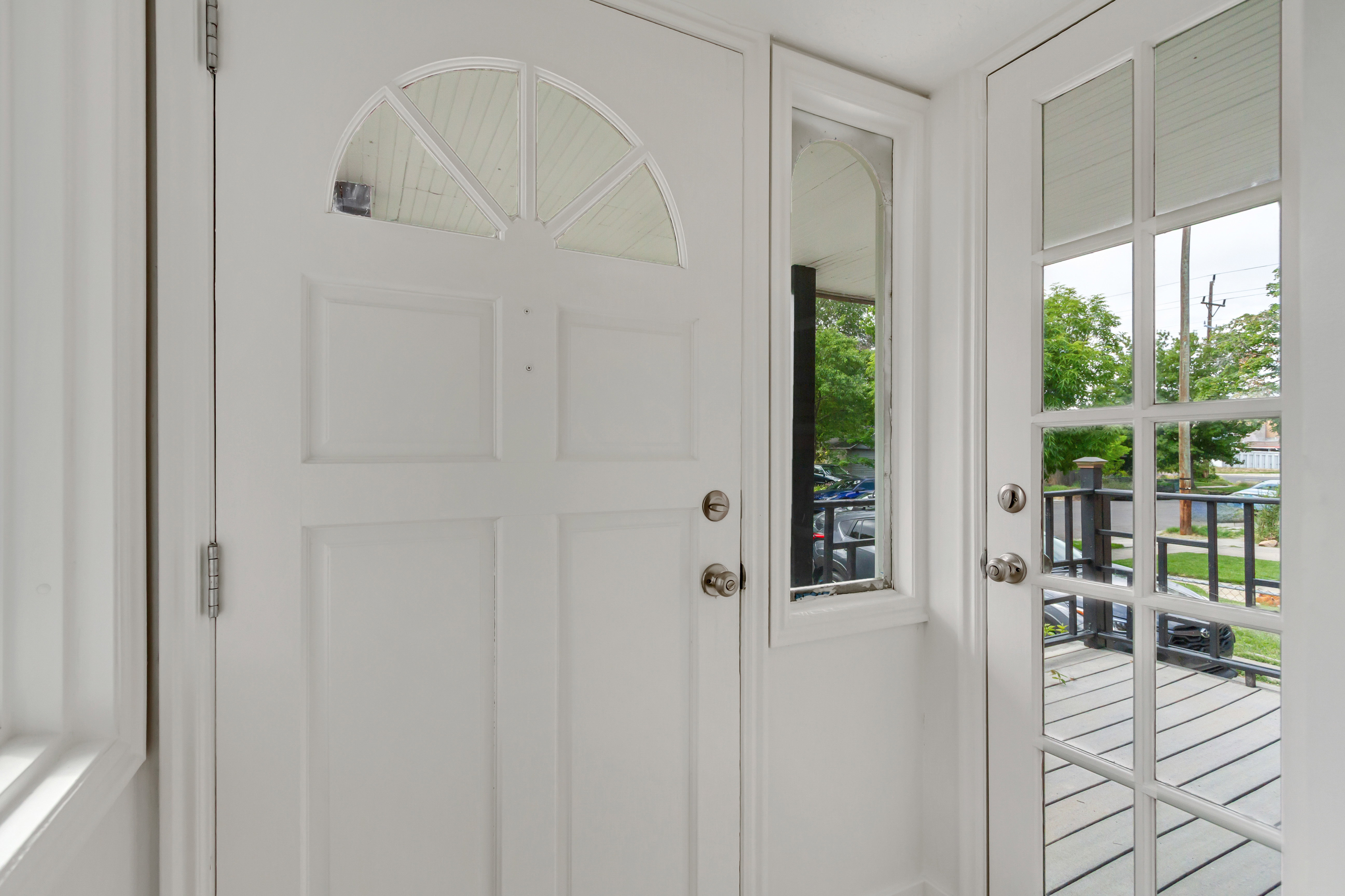 Entryway featuring a paneled door with an arched transom window, a rectangular sidelight, and a glass-paned door