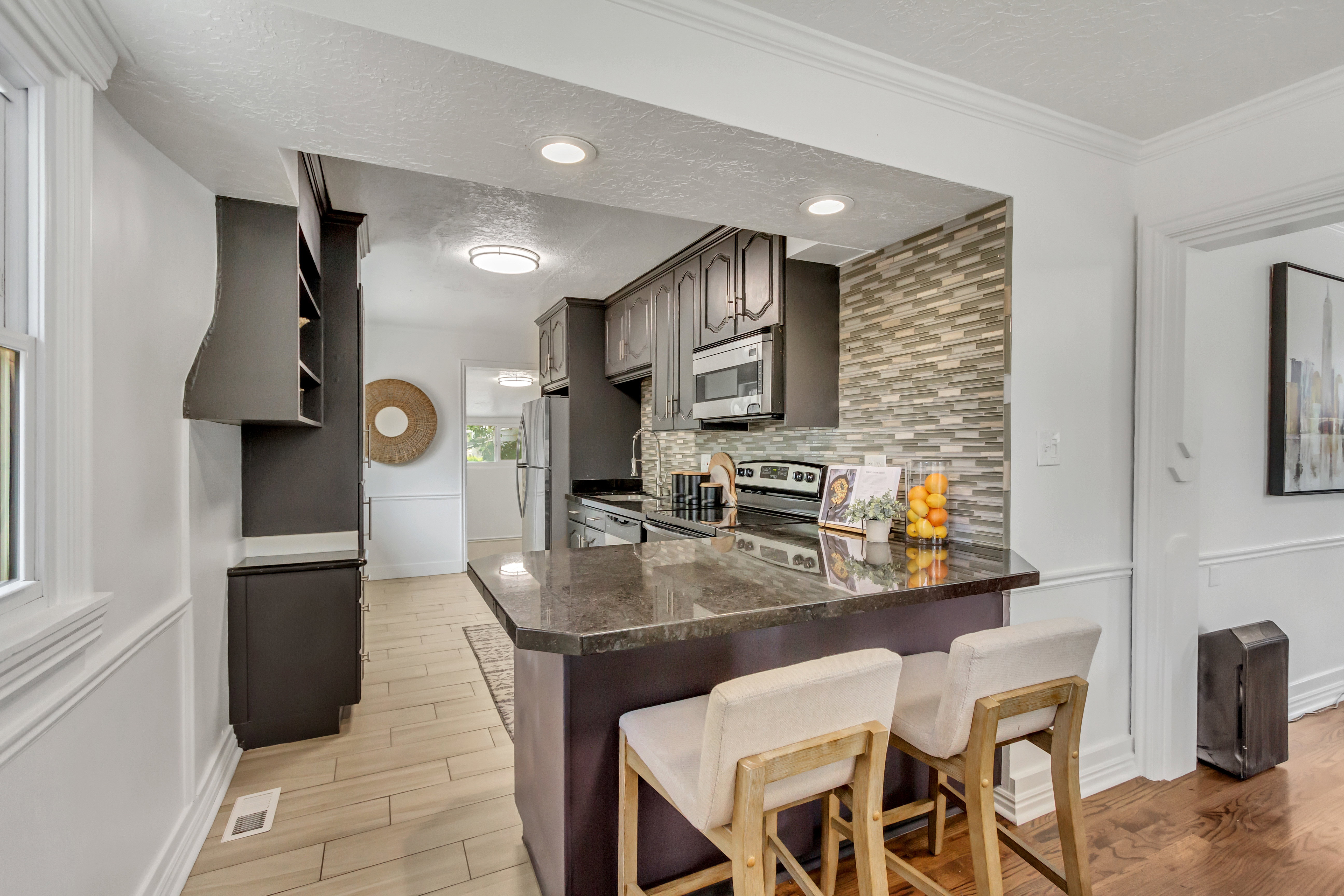 Kitchen featuring dark cabinetry, stainless steel appliances, and a tiled backsplash