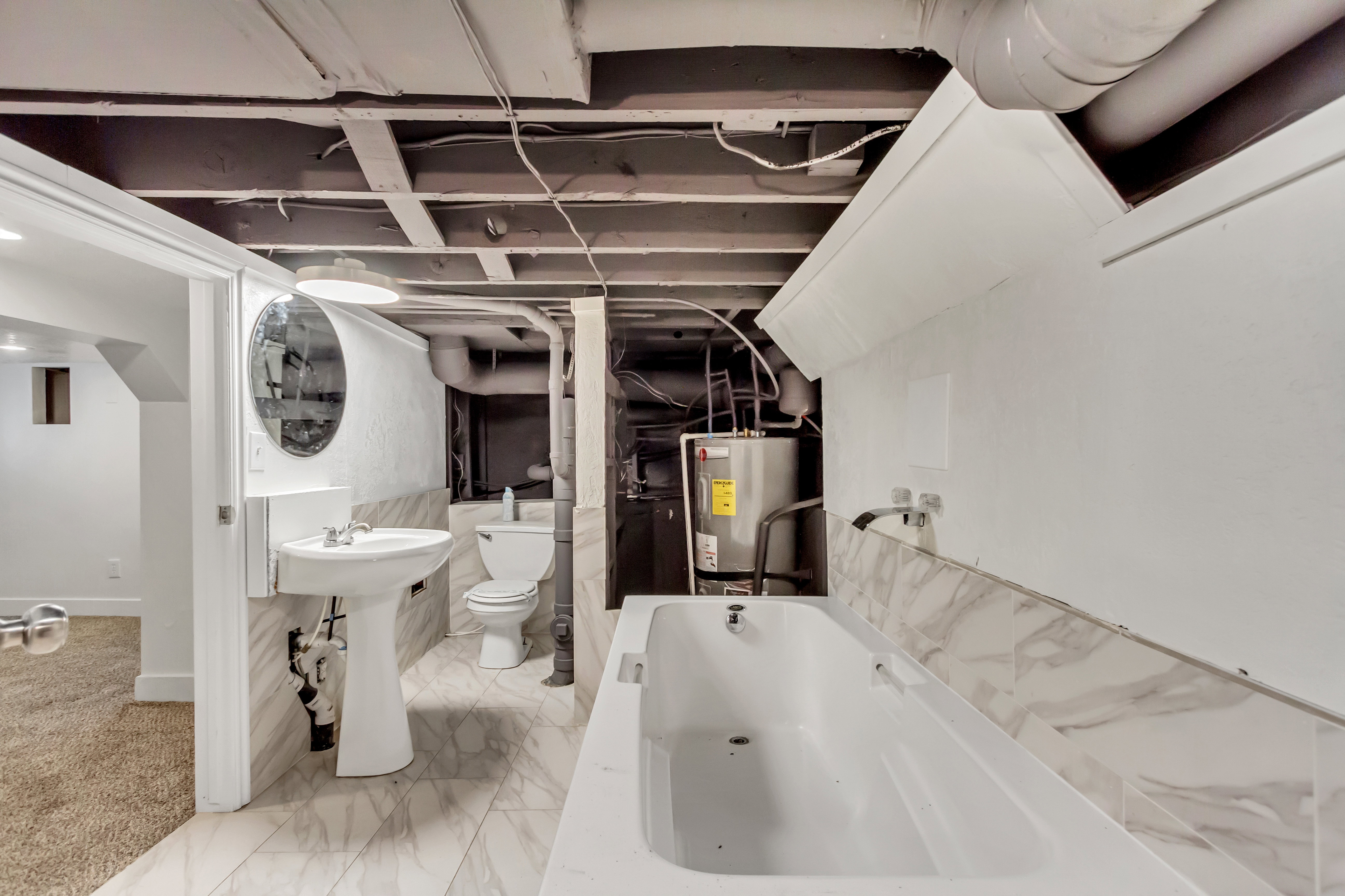 Bathroom featuring a white pedestal sink, toilet, and bathtub