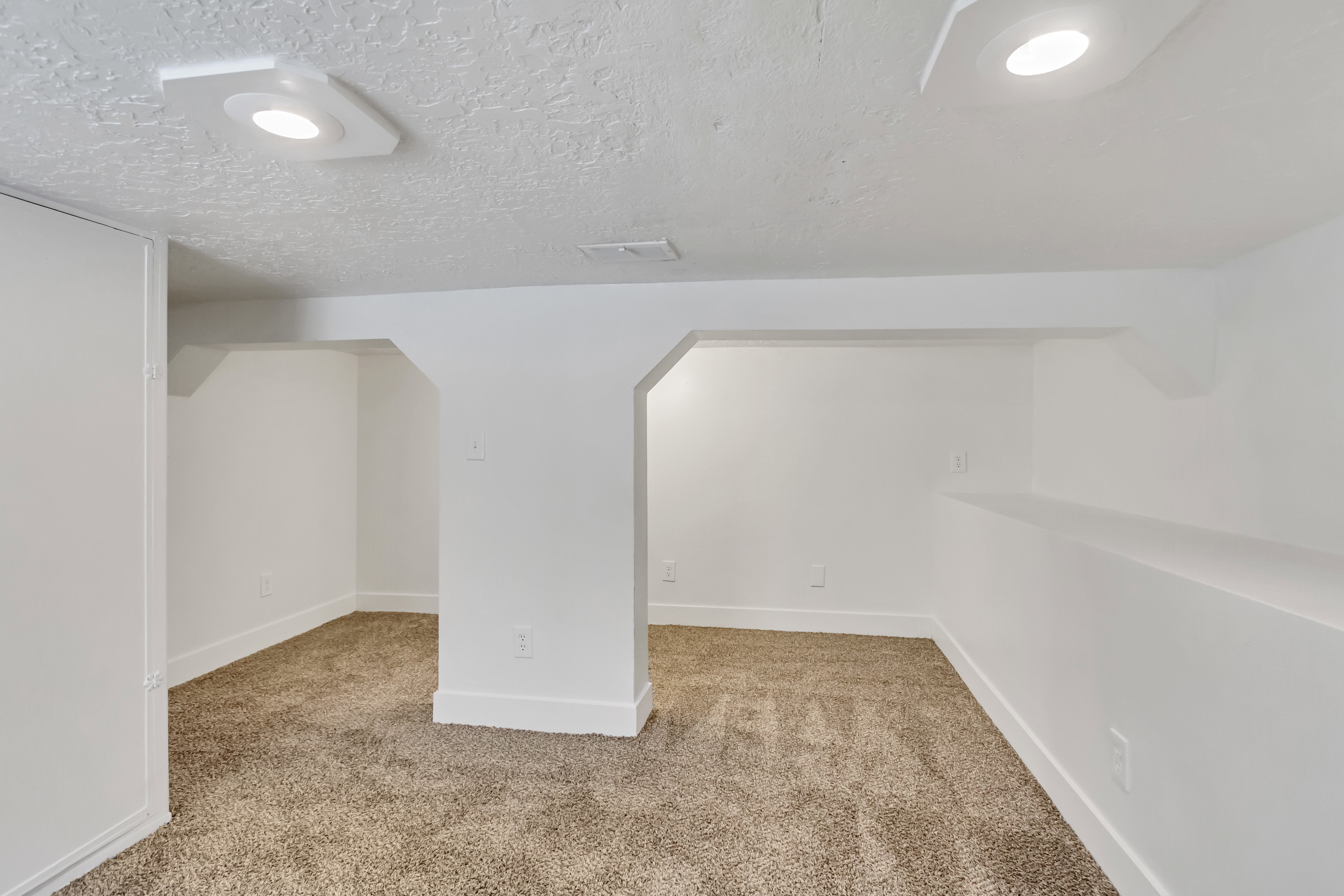 Carpeted room featuring white painted walls and ceiling