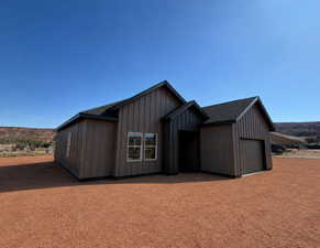 RENDERING. Modern single-story residence with vertical siding, pitched shingle roof, and attached garage.