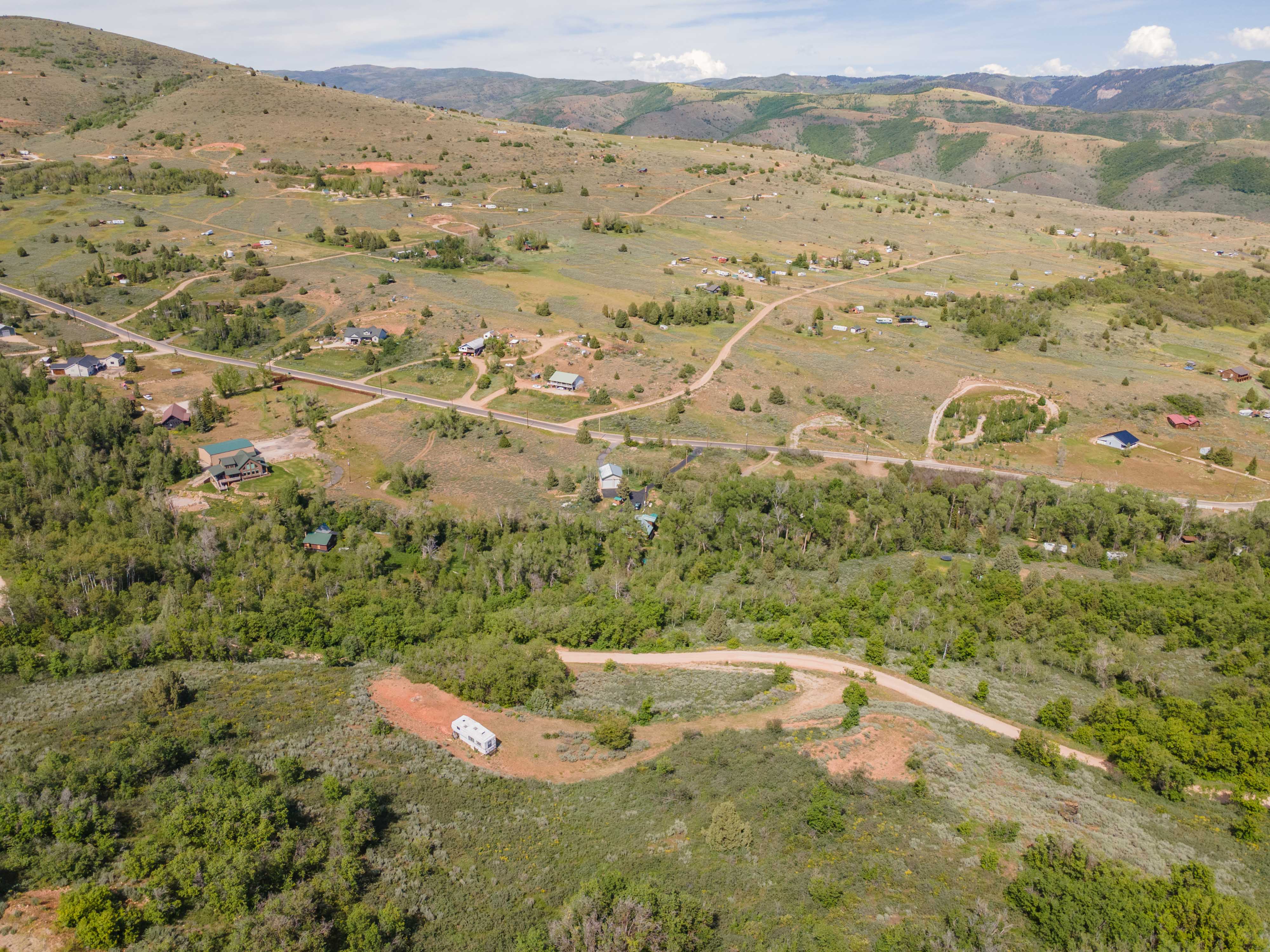 Expansive acreage featuring mature trees, varying terrain, and distant mountain ranges