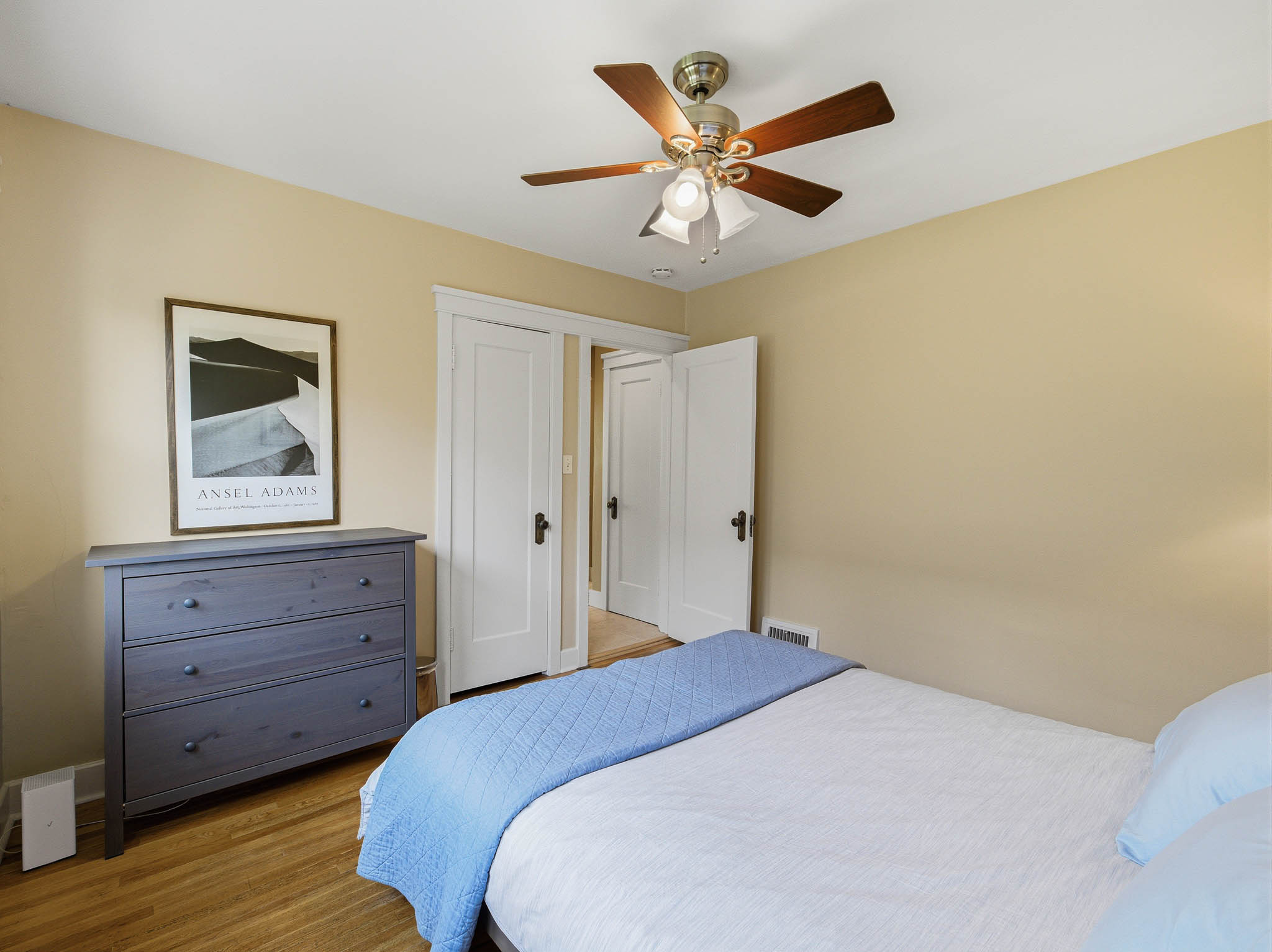 Bedroom featuring wood-finish flooring, a ceiling fan with light fixture, and neutral wall tones