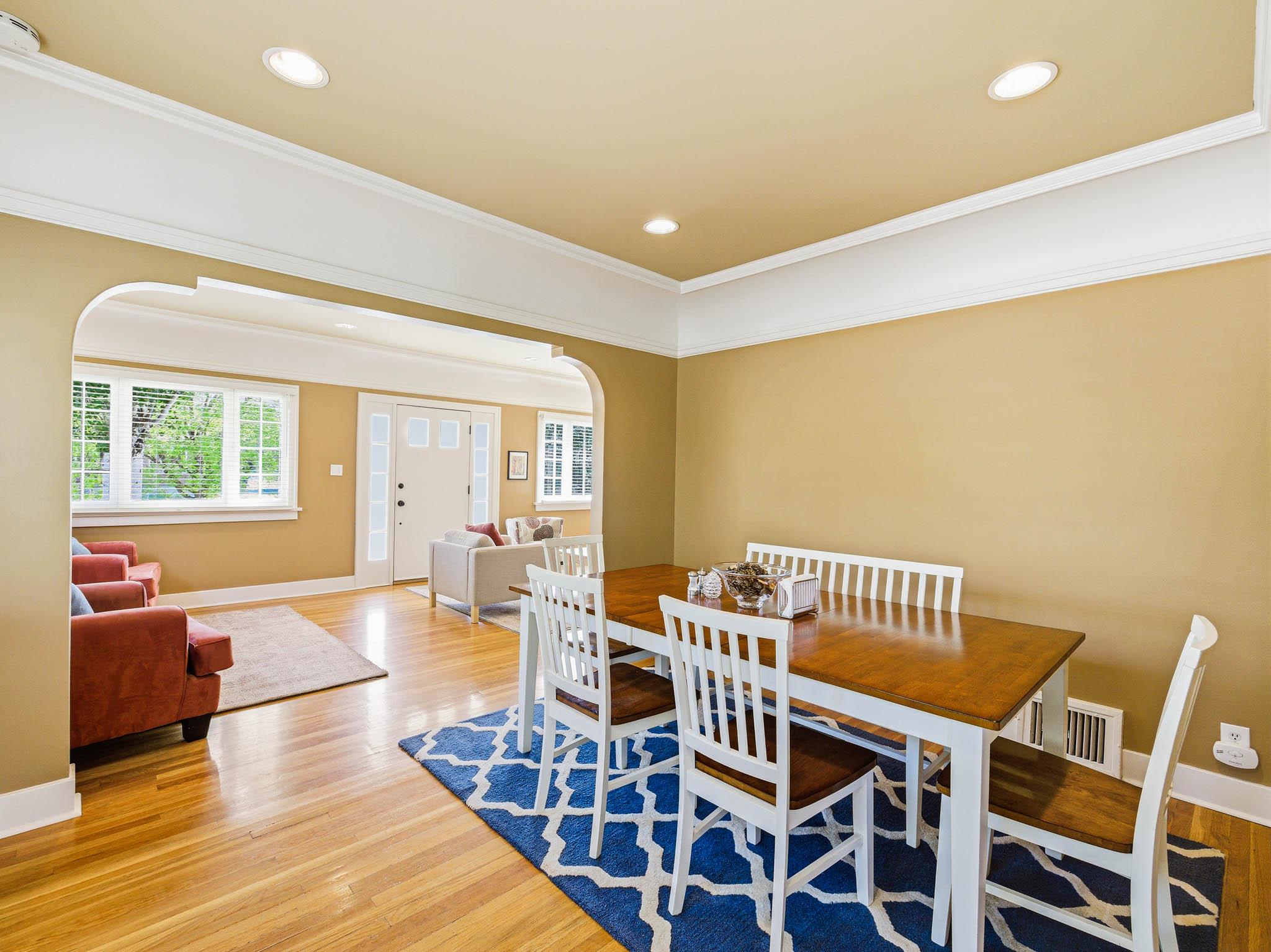 Dining area featuring wood-finish flooring, recessed lighting, and an arched entryway