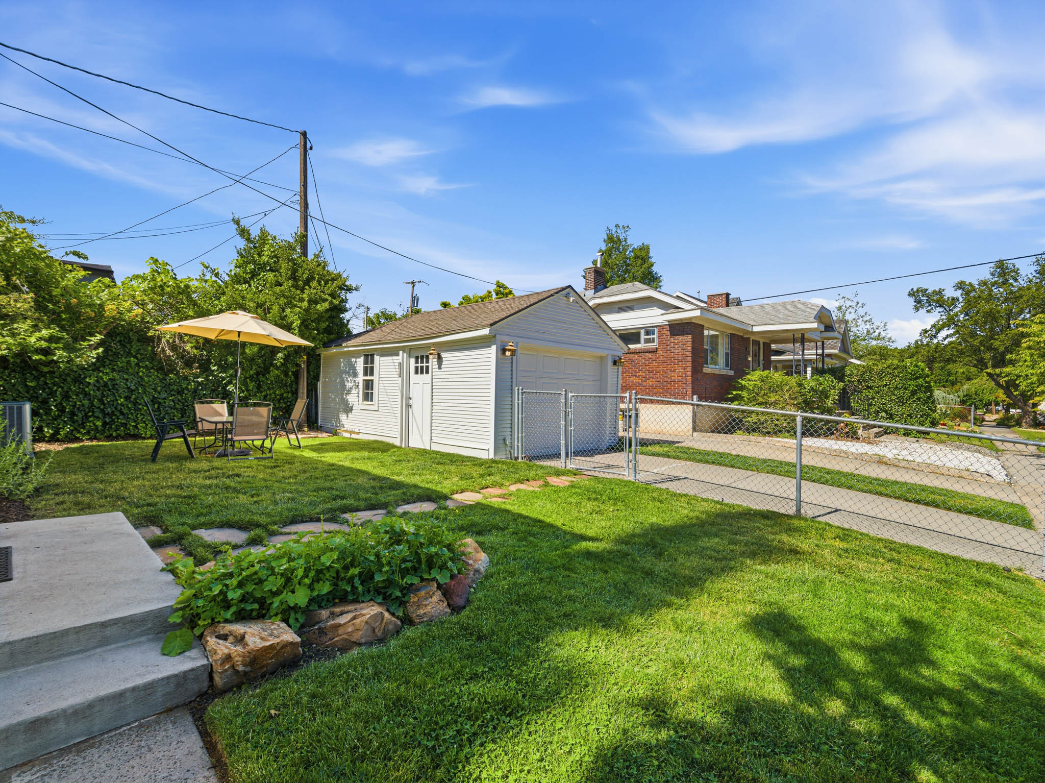 Detached garage with horizontal white siding and a paneled overhead door