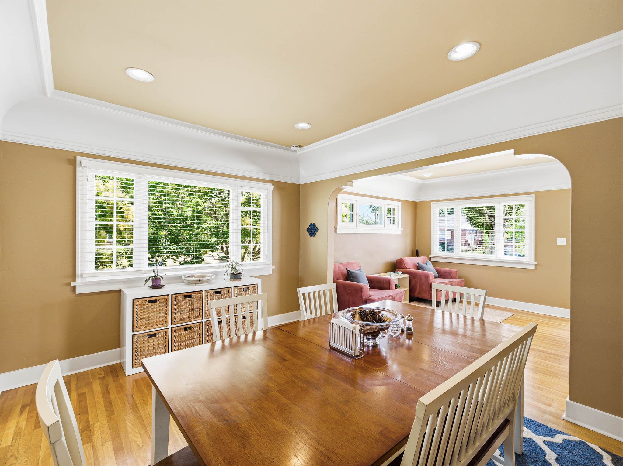 Open-concept dining area featuring wood-finish flooring, a large window with white blinds, and recessed lighting