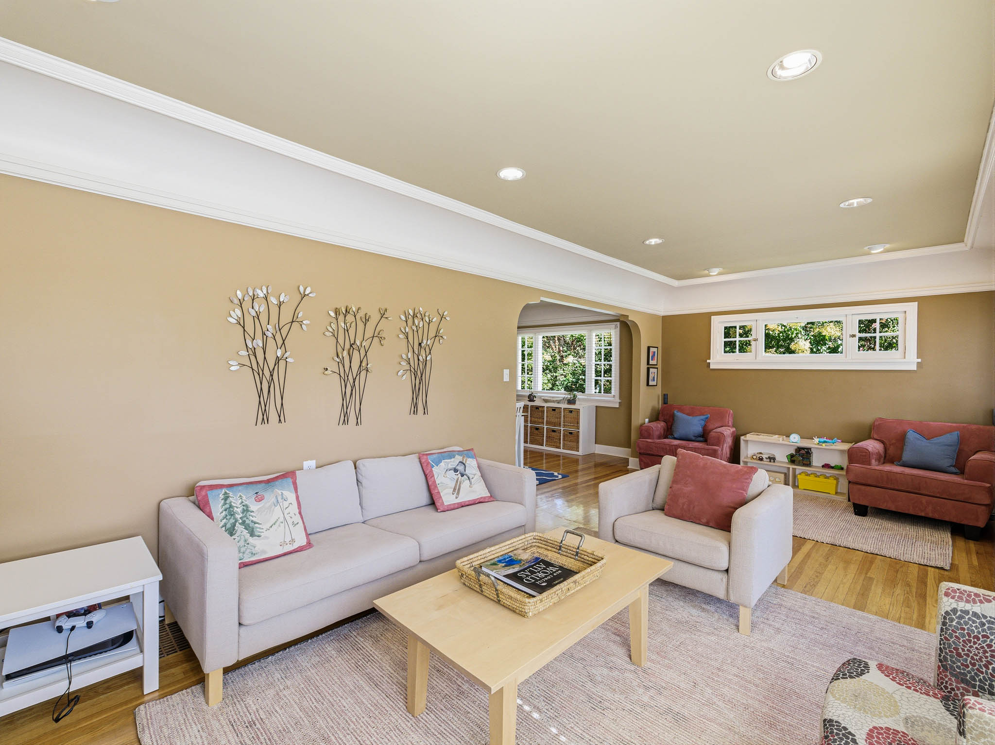 Living area with wood-finish flooring, recessed lighting, white crown molding, and multiple windows providing natural light