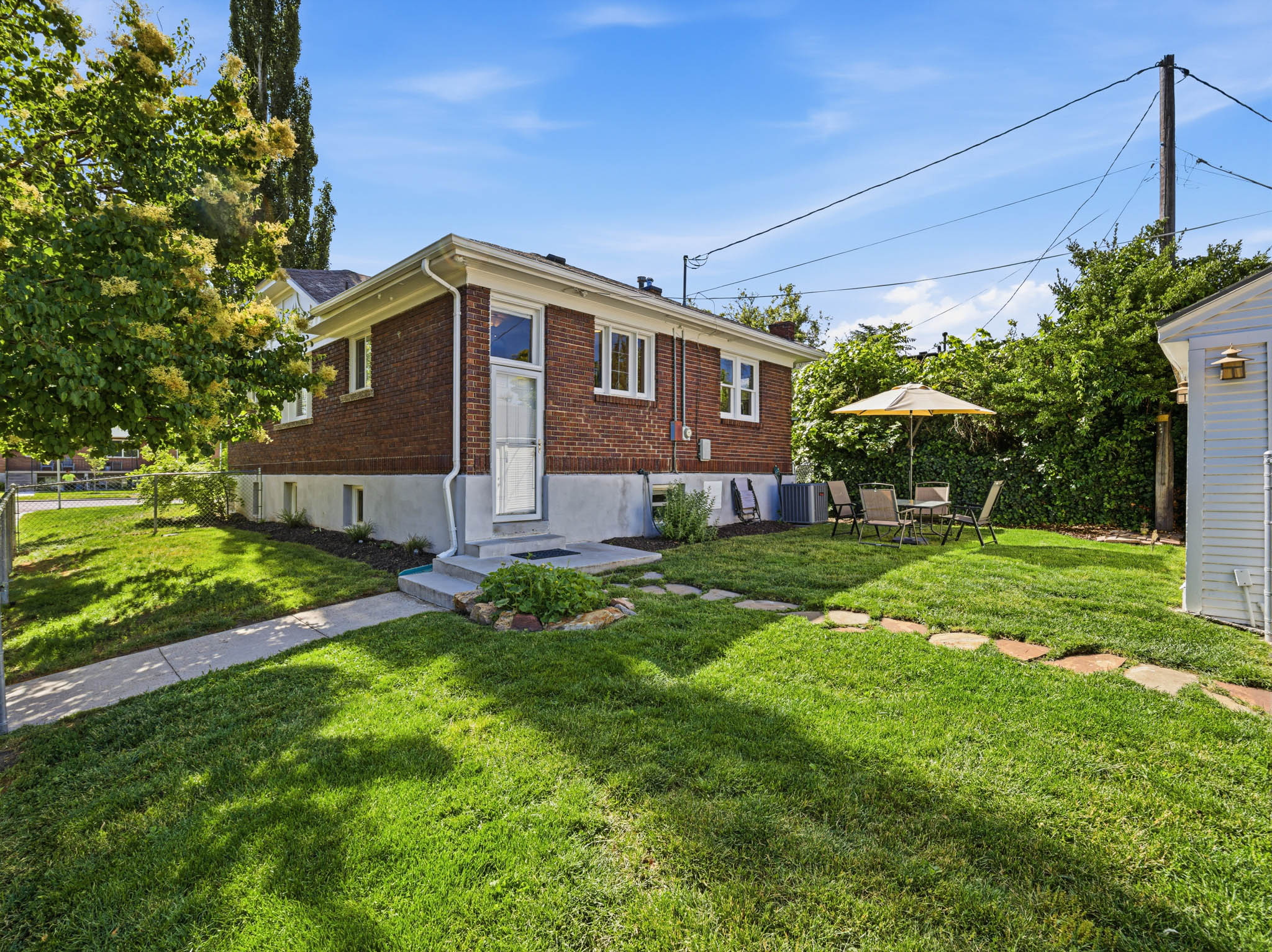 Brick exterior featuring white trim and a concrete foundation