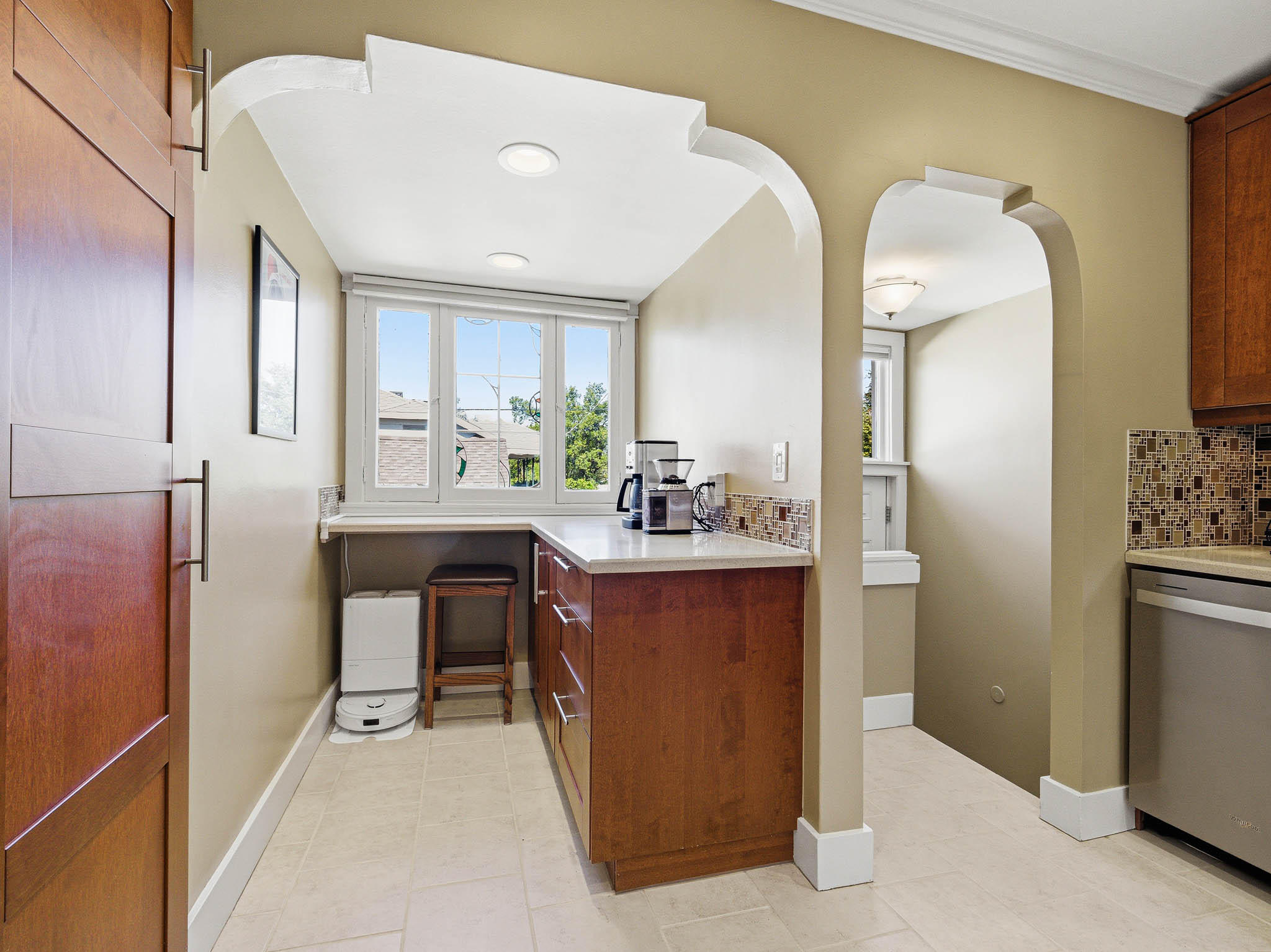 Kitchen alcove featuring a multi-pane window, recessed lighting, and an arched entry