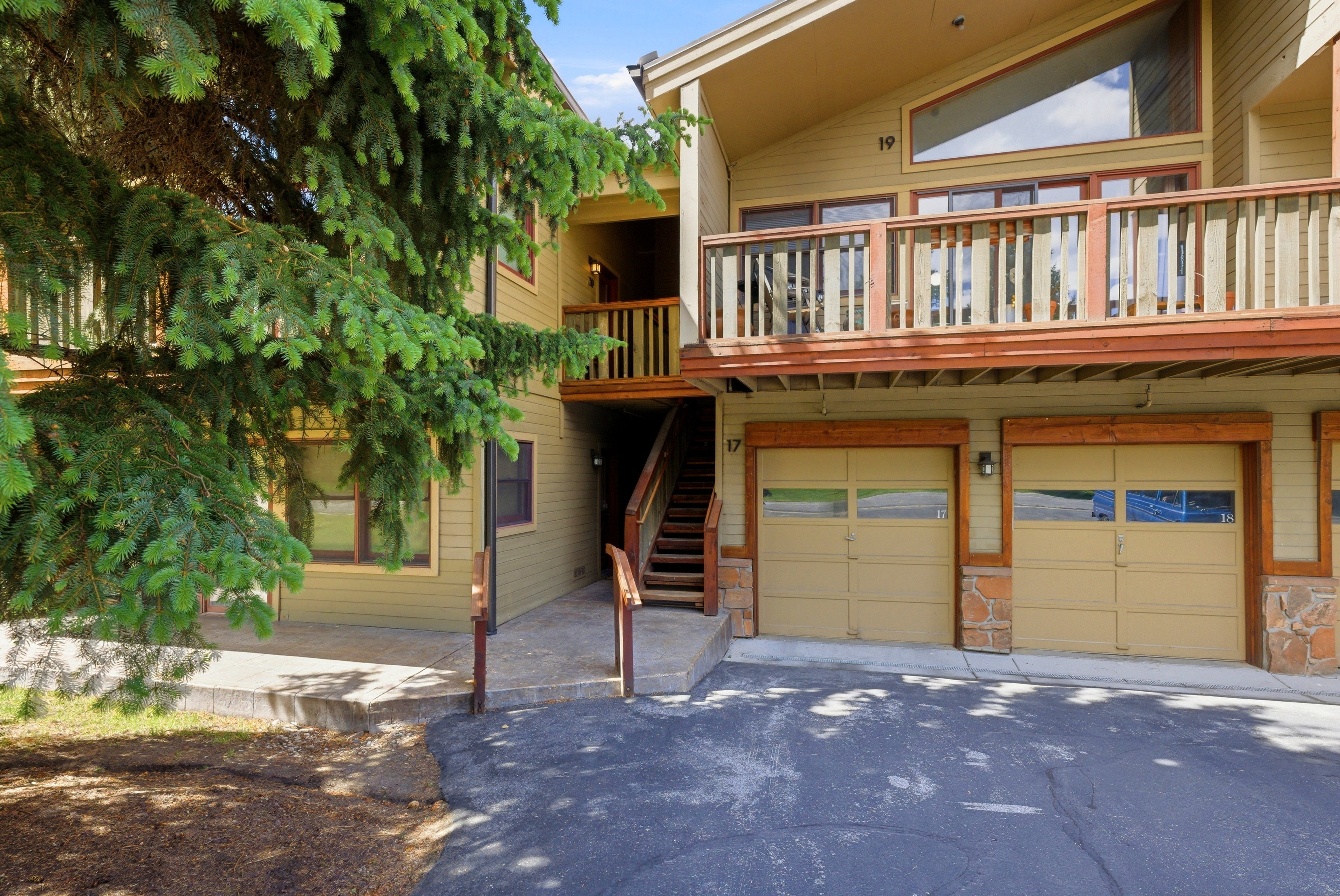 Exterior featuring light tan siding and natural wood accents