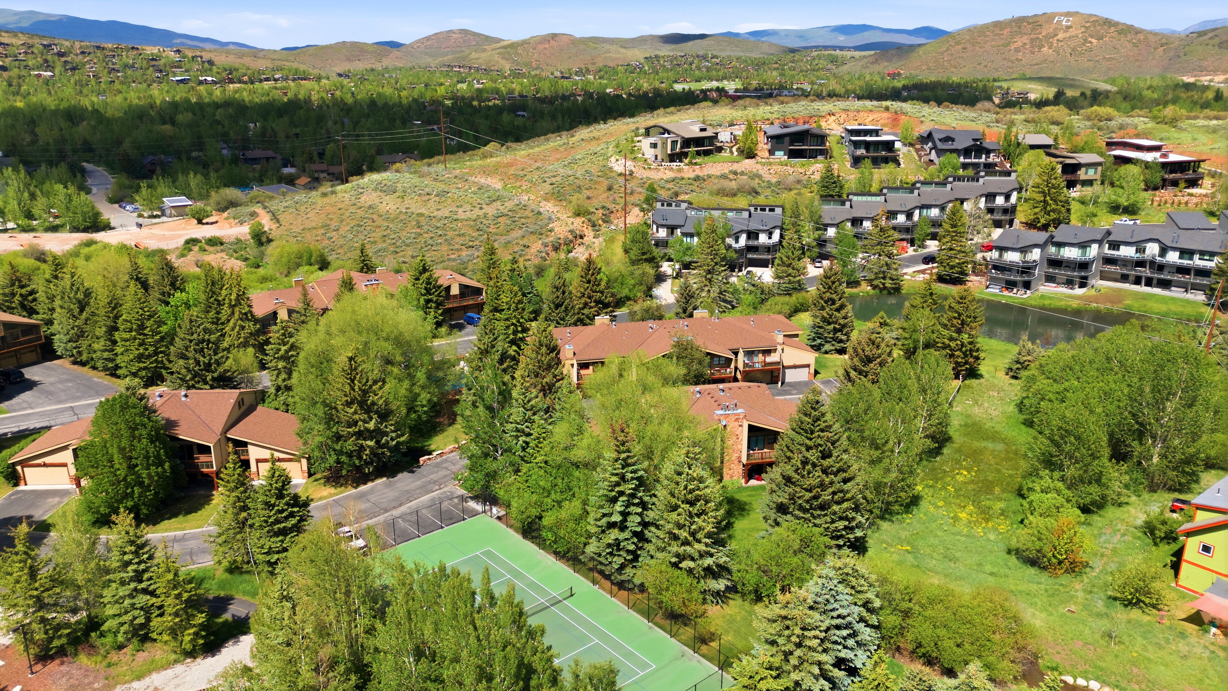 Aerial perspective showcasing a residential community nestled among mature trees and rolling hills