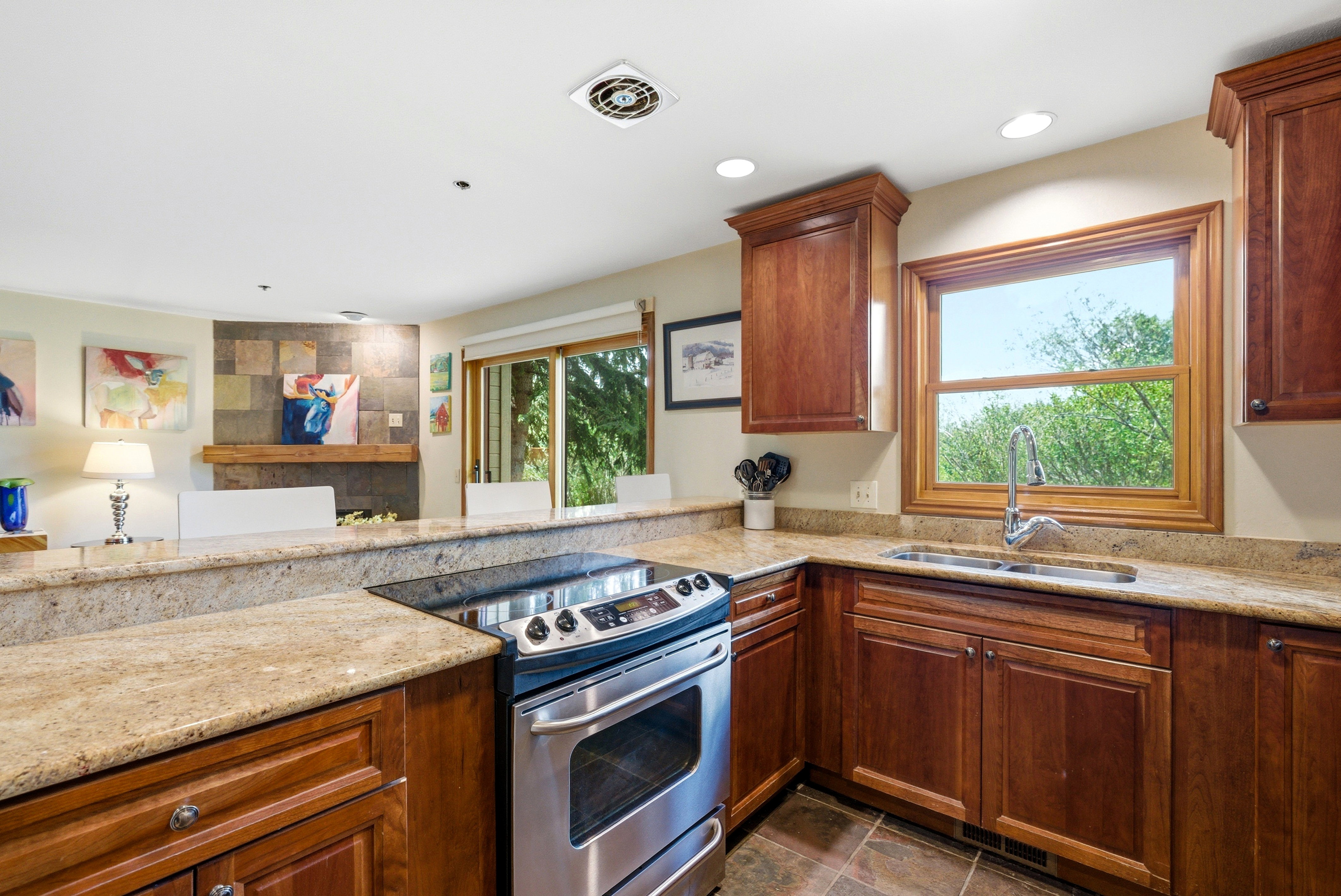 Kitchen featuring rich wood cabinetry, stainless steel range, and light-toned stone countertops
