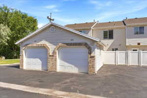 Attached two-car garage featuring brick accents and a gabled roofline