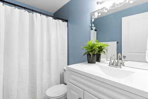 White vanity with integrated sink, brushed nickel faucet, and decorative wall mirror
