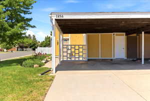 Carport with exposed wood ceiling beams and concrete flooring