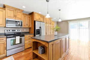 Kitchen featuring wood cabinetry, stainless steel appliances, and stone-finish countertops