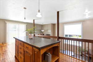 Kitchen island with a dark countertop and wood-finish cabinetry