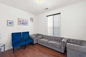 Open-concept room featuring wood-finish flooring, light-toned walls, and a window with blinds