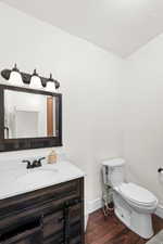 Powder room featuring a dark wood-finish vanity with a white countertop, undermount sink, and matte black faucet