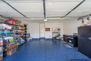 Spacious two-car garage featuring a speckled blue epoxy floor and white walls