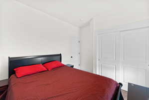White painted walls with a recessed light fixture, wood-finish flooring, and two paneled sliding closet doors