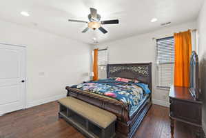 Bedroom featuring wood-finish flooring, two windows with blinds, a ceiling fan with integrated lighting, and recessed ceiling lights