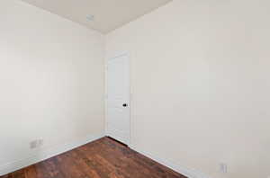 Interior space featuring wood-finish flooring, light-toned walls, and white baseboards