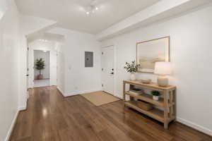 Spacious hallway featuring wood-finish flooring, white walls, recessed ceiling lights, and white trim