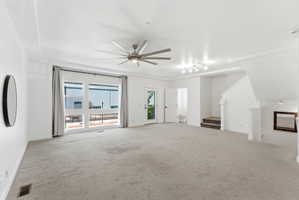 Expansive living area featuring light gray carpeting, a contemporary ceiling fan, and large windows with gray drapery
