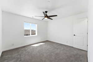 Room featuring a white ceiling and walls, gray carpet, and a modern black ceiling fan