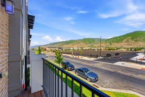 Private balcony featuring wood-finish flooring and black metal railings