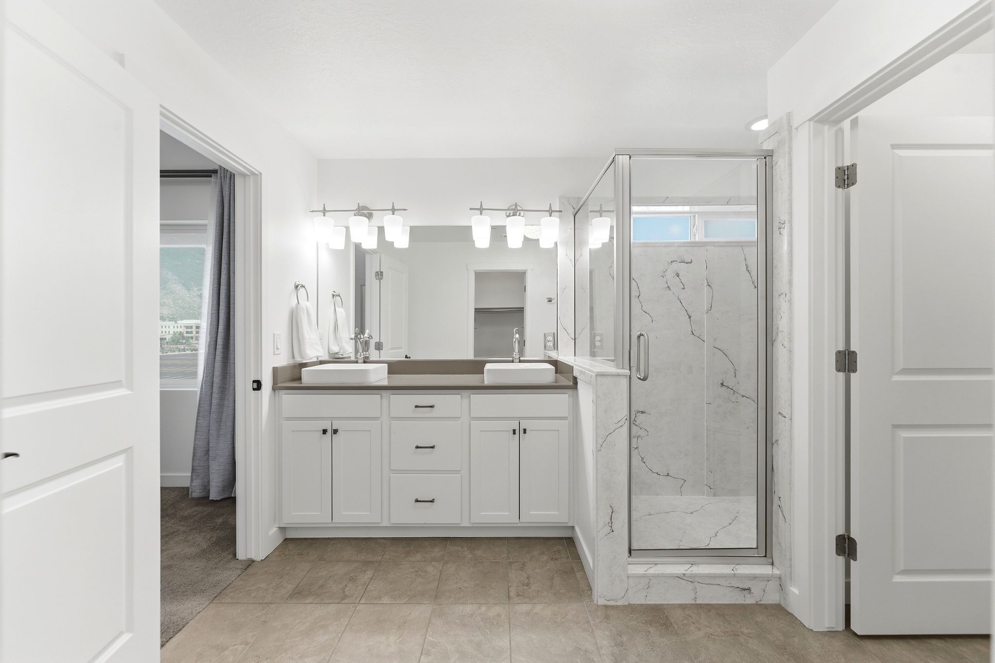 Dual vanity with undermount sinks and contemporary light fixtures