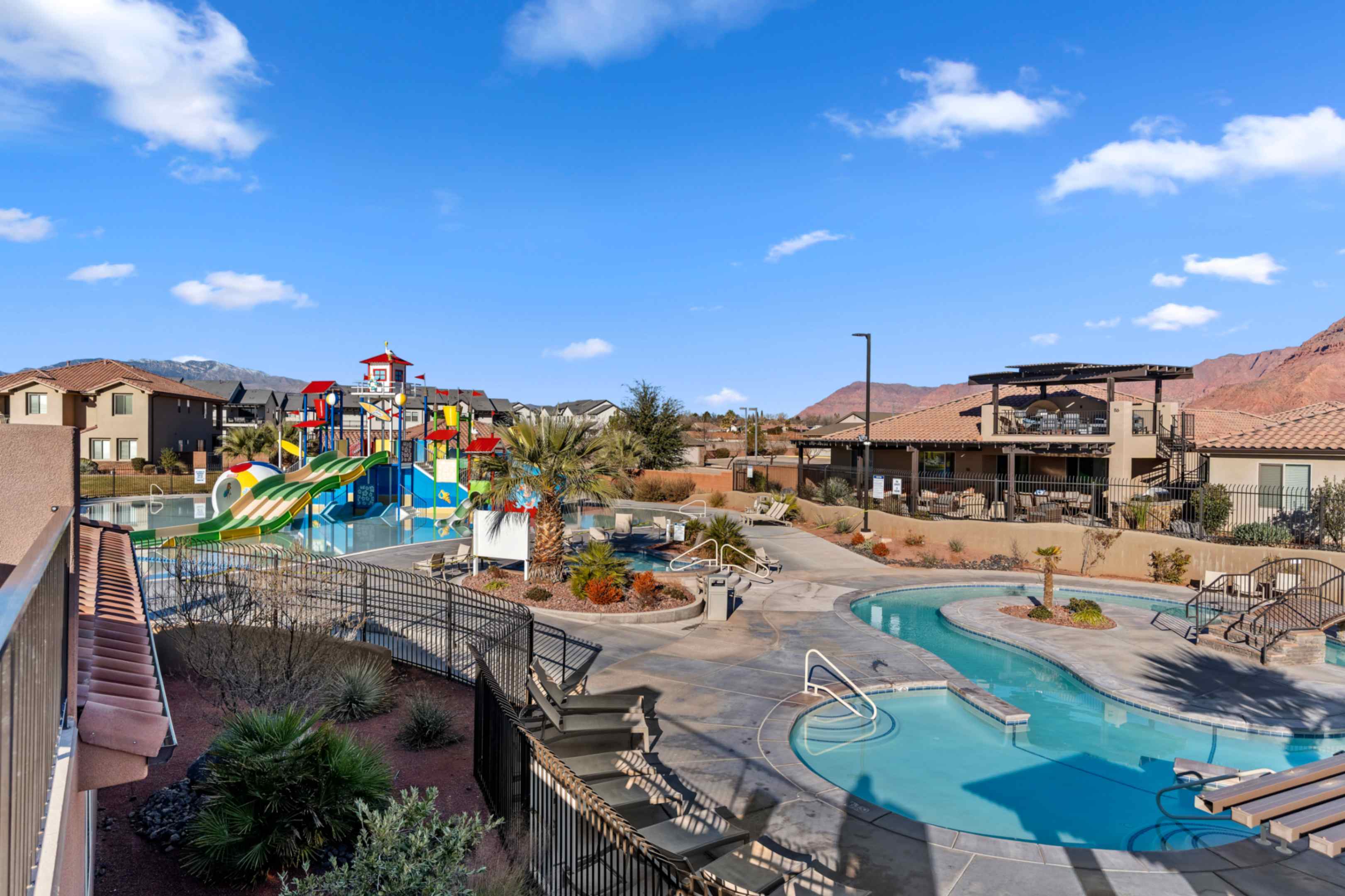 Community pool area featuring a lazy river, water park structure, and expansive sundeck