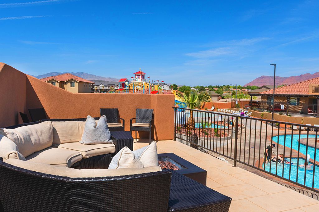 Rooftop patio featuring a built-in fire pit, paved surface, and wrought iron railing