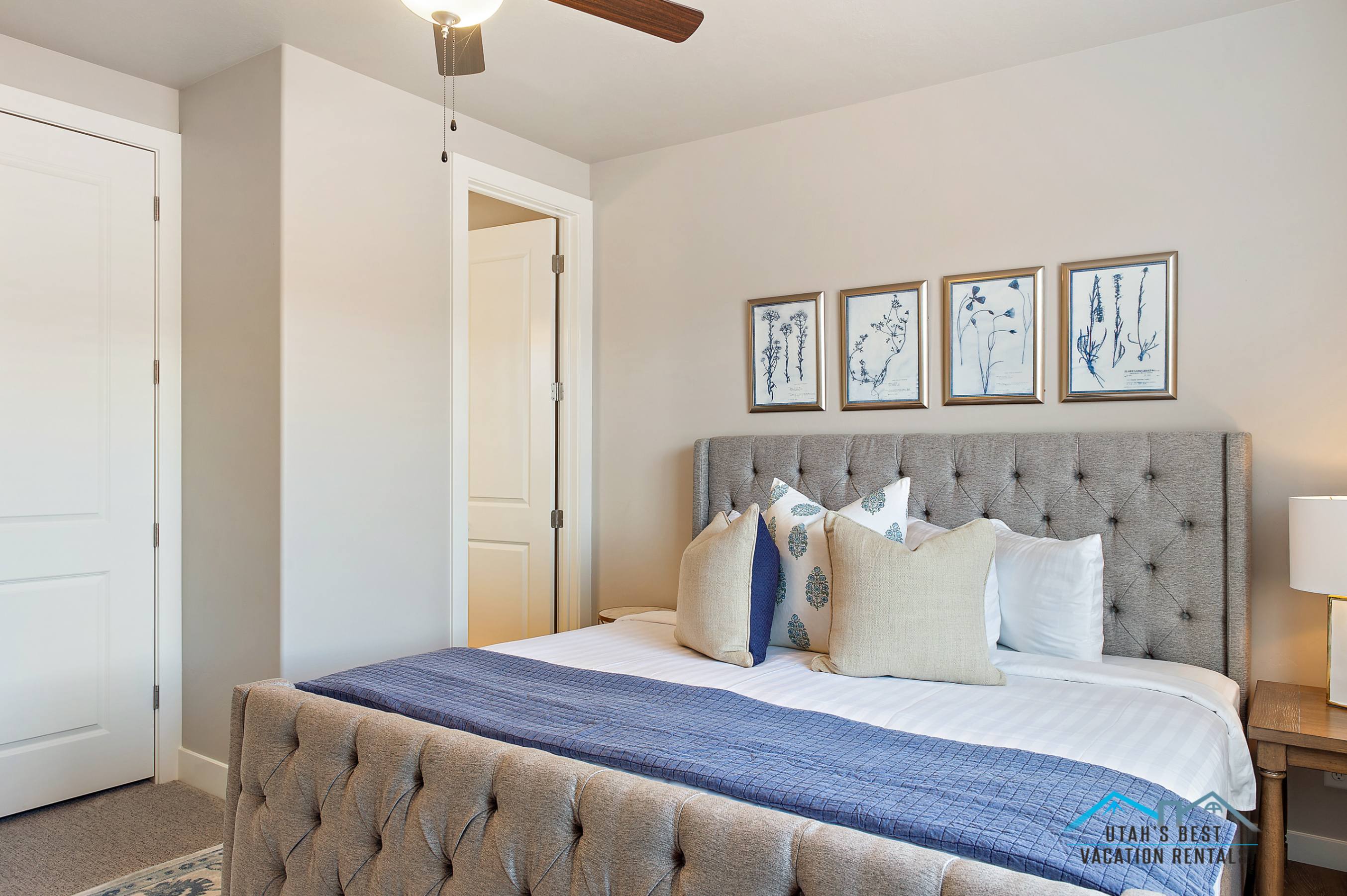 Bedroom featuring a tufted upholstered bed frame, light neutral wall paint, and white trim