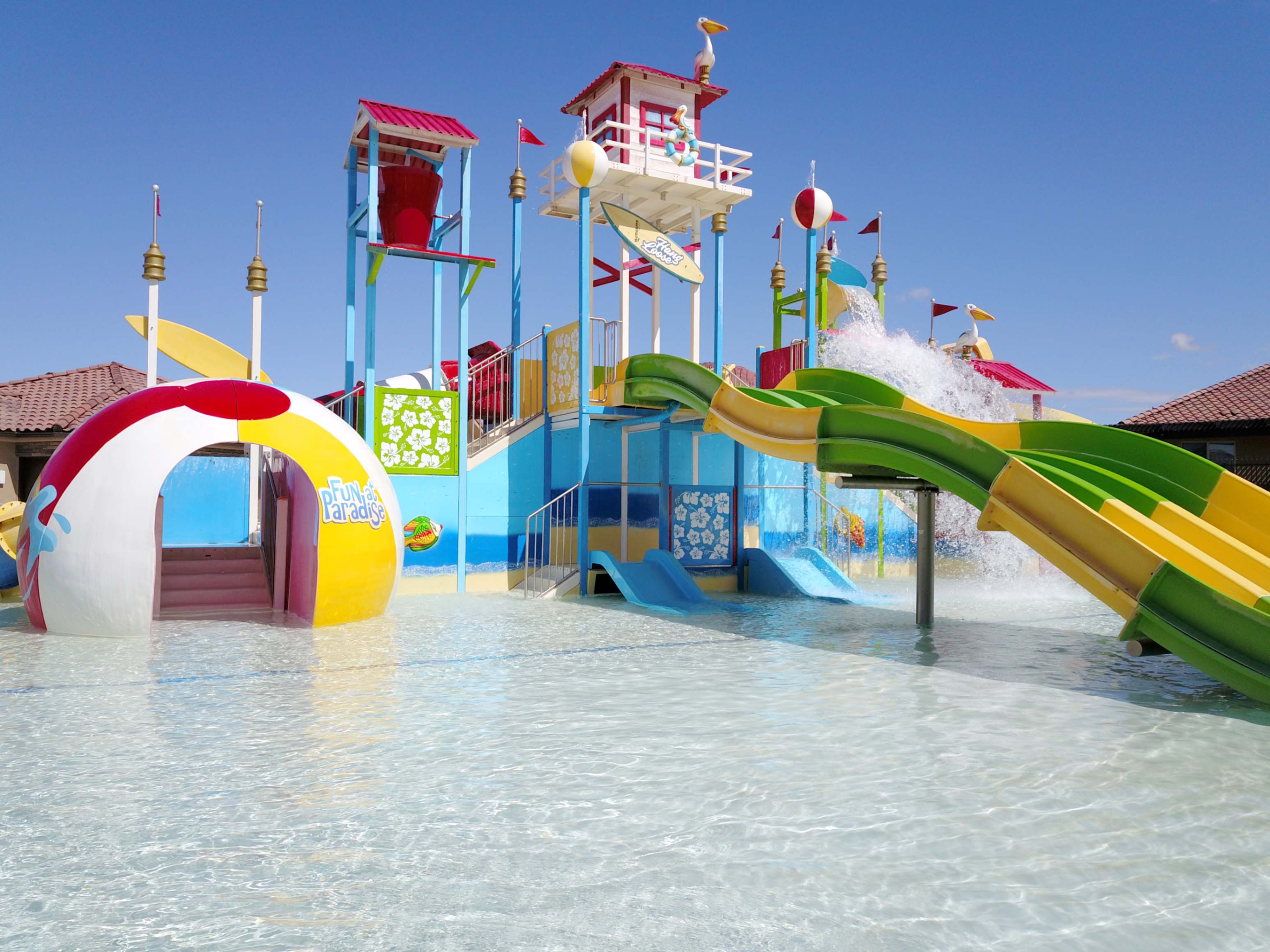 Expansive aqua park featuring multiple colorful water slides, a large splash bucket, and an interactive play structure